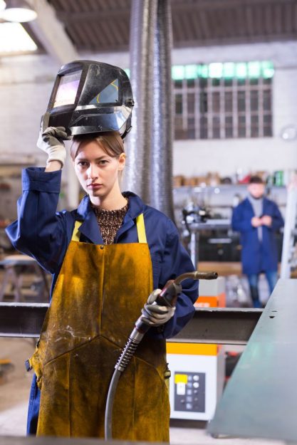 Portrait of female welder in factory workshop